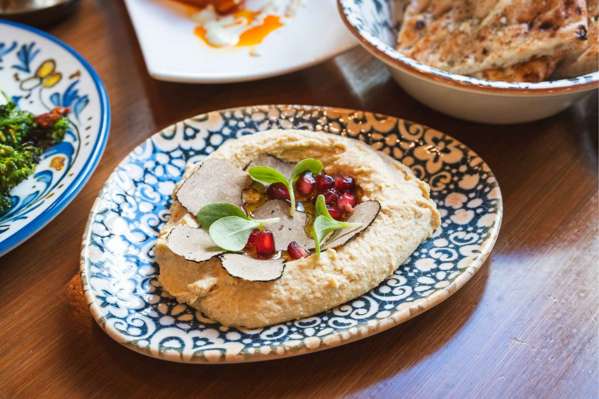 Bild eines veganen Hummus Gerichts angerichtet mit schwarzem Trüffel