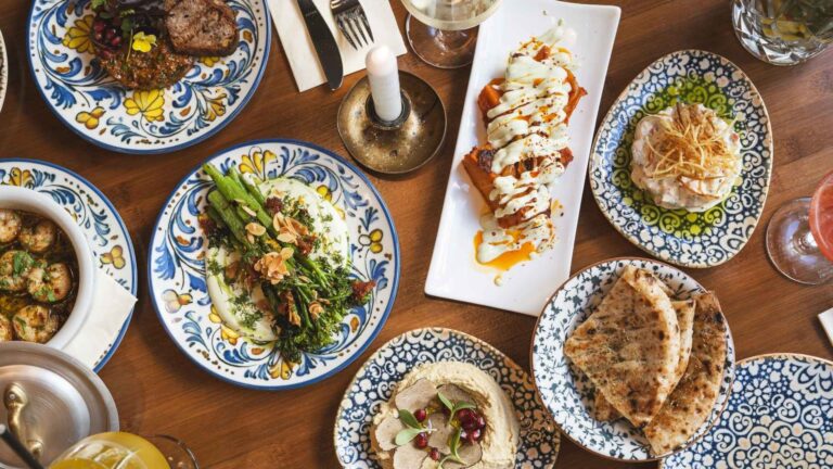 Vegane und vegetarisches Speisen sowie mediterrane Fleischgerichte serviert auf einem Holztisch