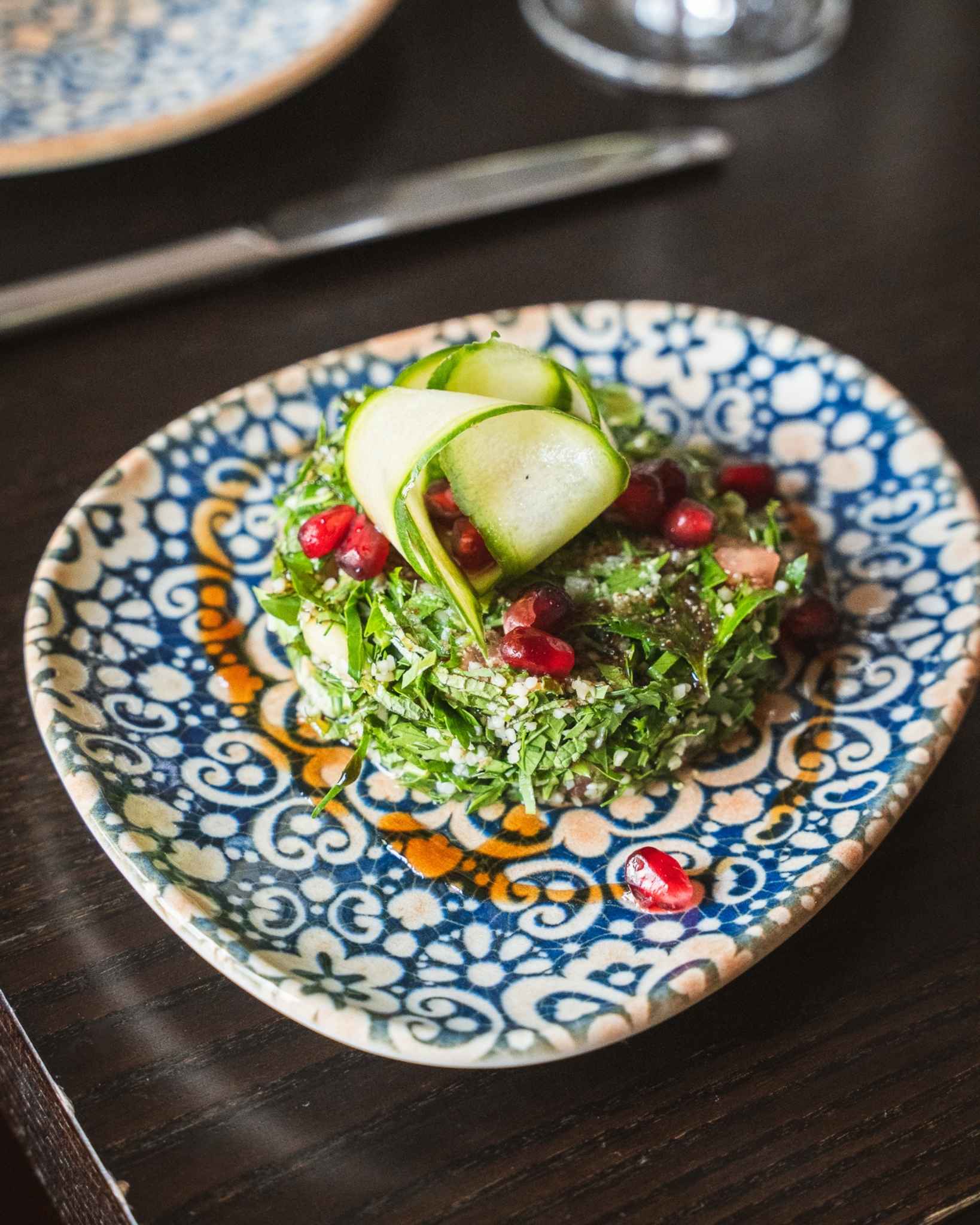 Ansicht eines vegetarischen Gerichts serviert mit vielen frischen Kräutern und modern interpretiert