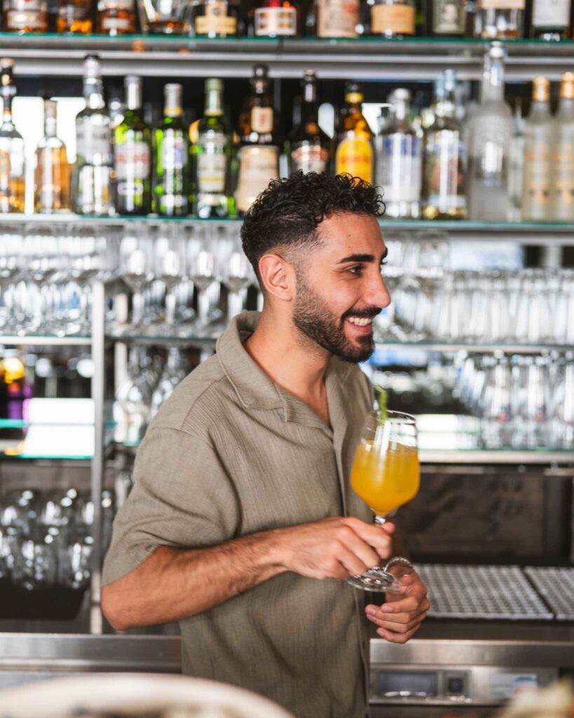 Gut gelaunter Gastgeber geht von der Bar aus los, um den bestellten Drink zu servieren