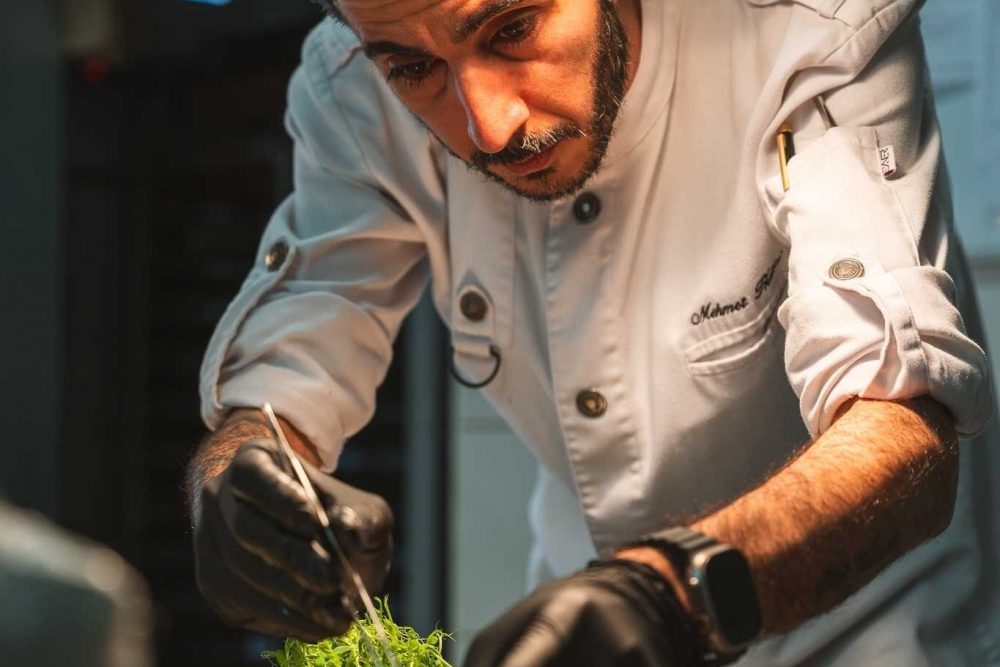 Der Koch von Levante München bereitet die Speisen beim Catering zu